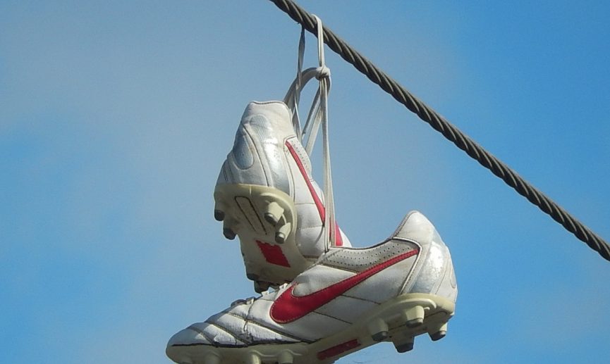 A pair of soccer cleats hanging from a wire