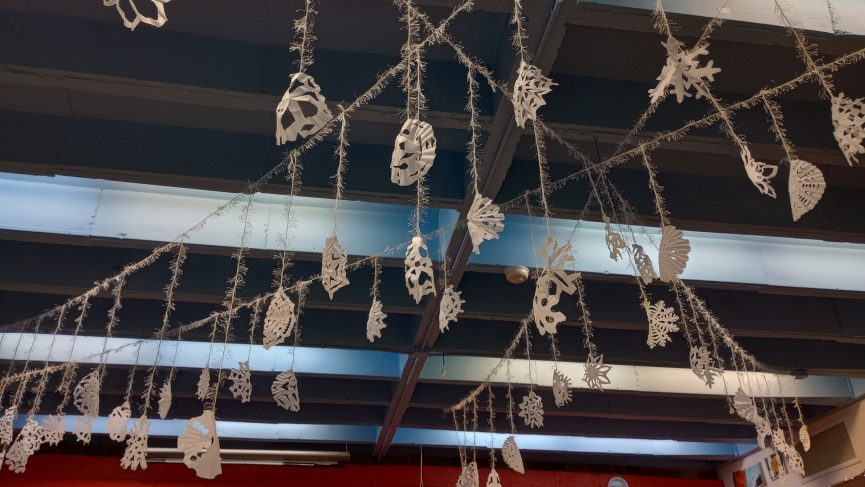 Many cutout snowflakes hanging from the ceiling